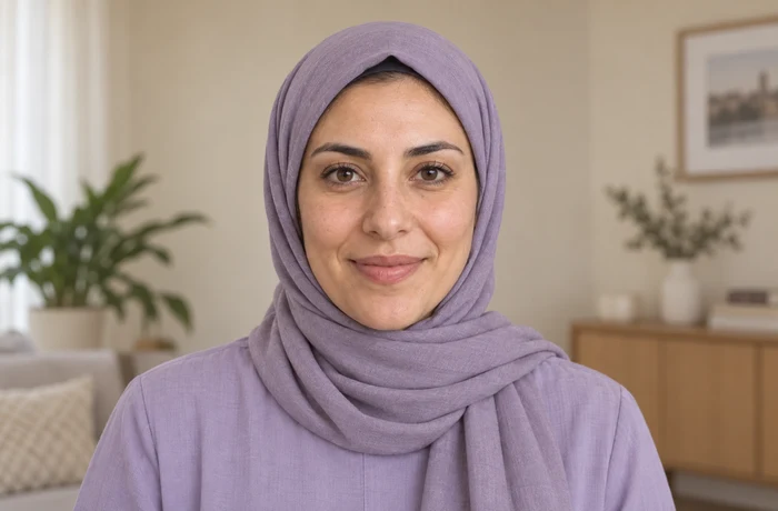 Later portrait of the same fictional woman wearing a hijab, with natural age-related facial changes